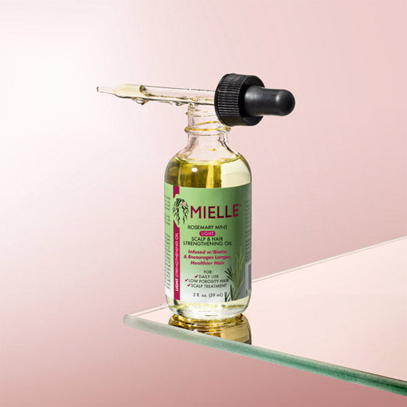 MIELLE rosemary mint hair oil glass dropper bottle on shelf with pink background for scalp care