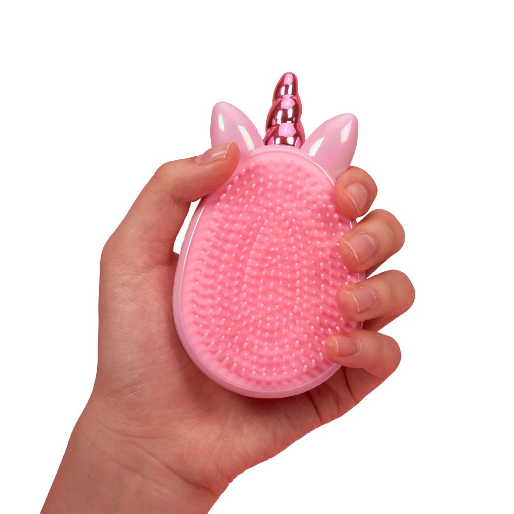Hand holding RED BEAUTY by KISS pink unicorn detangling brush with soft flexible bristles and horn