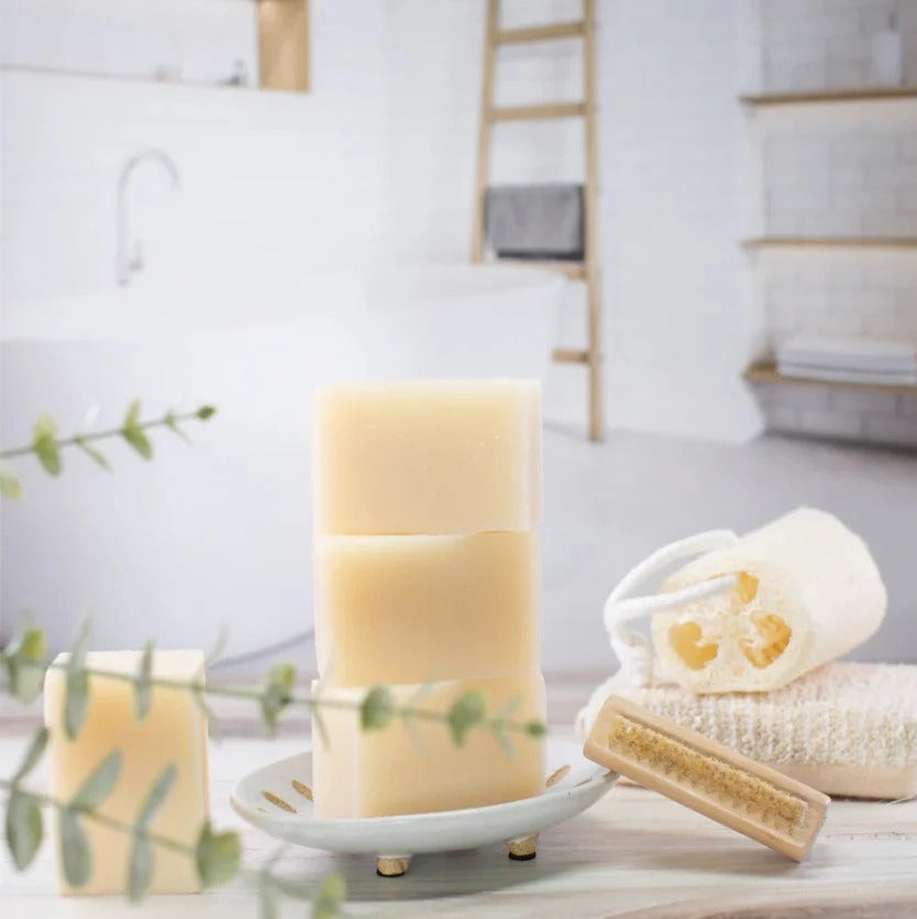 EARTH TO ME lavender relaxing bar soap stacked on a dish with bath accessories in a bright bathroom