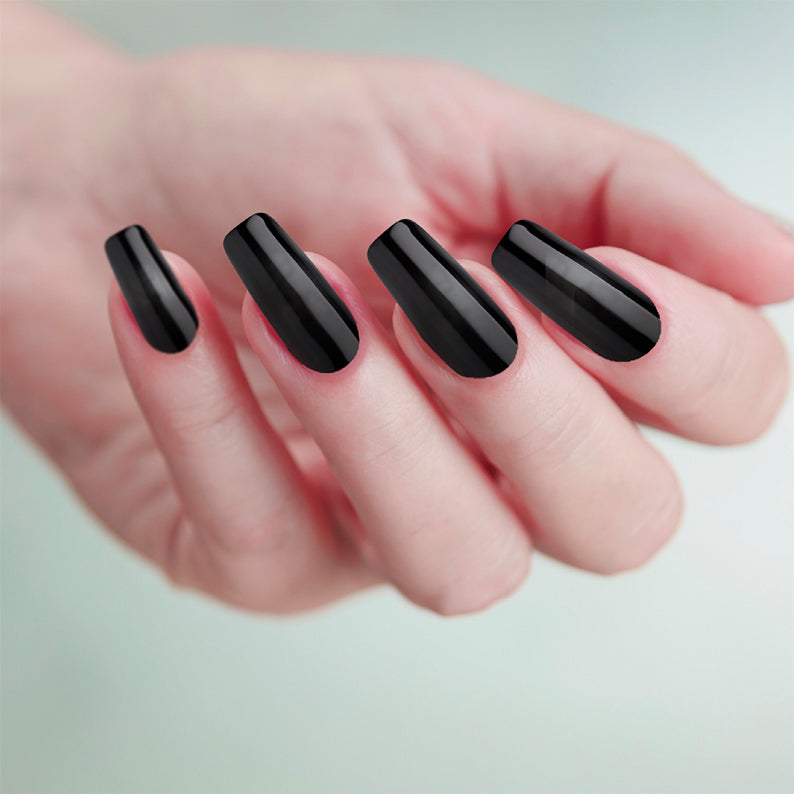 Hand with long glossy black coffin nails showcasing Gold Finger solid color fake nails by IVY BEAUTY