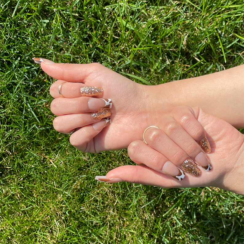 Gold Finger trendy press on nails on hands with gold glitter white French tips and black cow print accents
