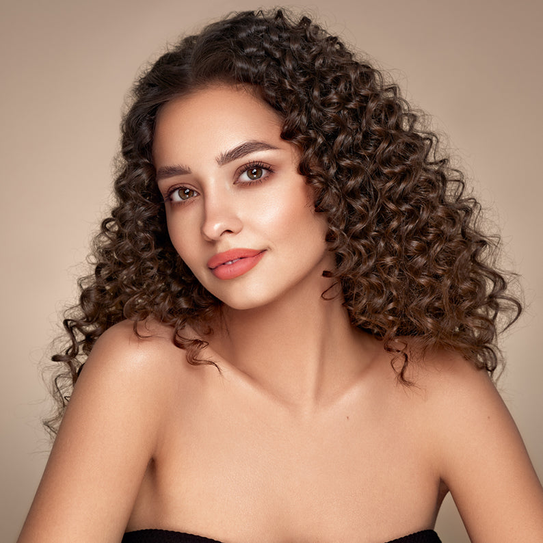Model with defined spiral curls made using ANNIE extra long ceramic curling iron for long lasting volume