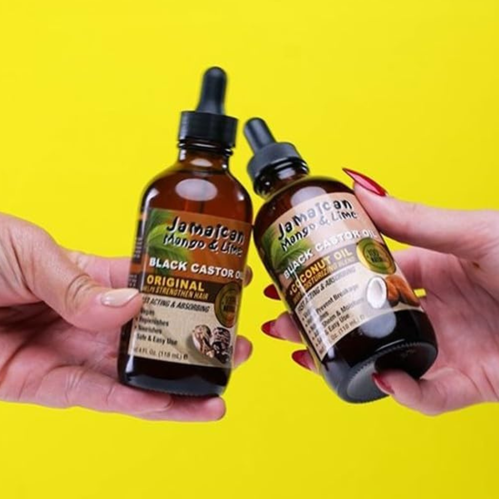 Jamaican black castor oil coconut bottles held by hands against a bright yellow background