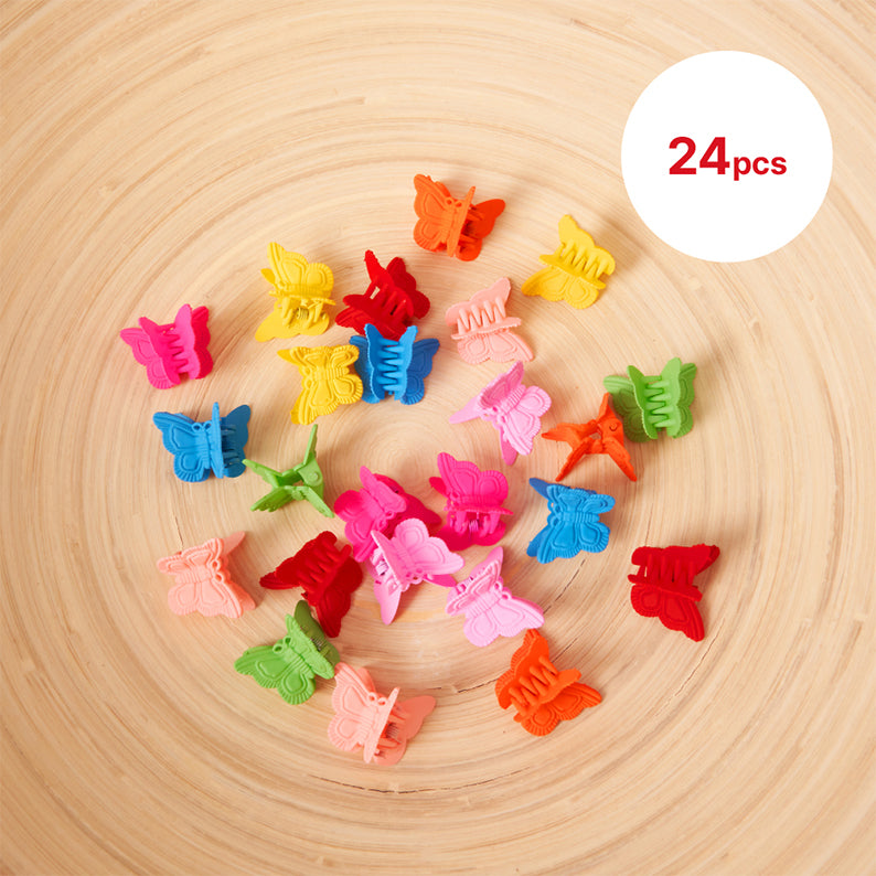 24pcs kids butterfly hair clips in various bright colors arranged on wooden surface