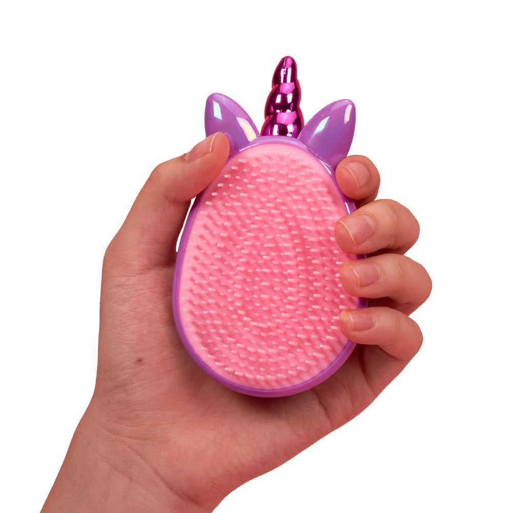 Hand holding pink and purple unicorn detangling brush for kids with soft bristles and ergonomic grip