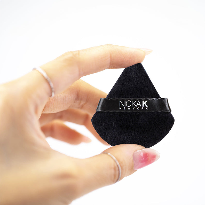 NICKA K mini setting powder puff in black held between fingers for precise makeup application