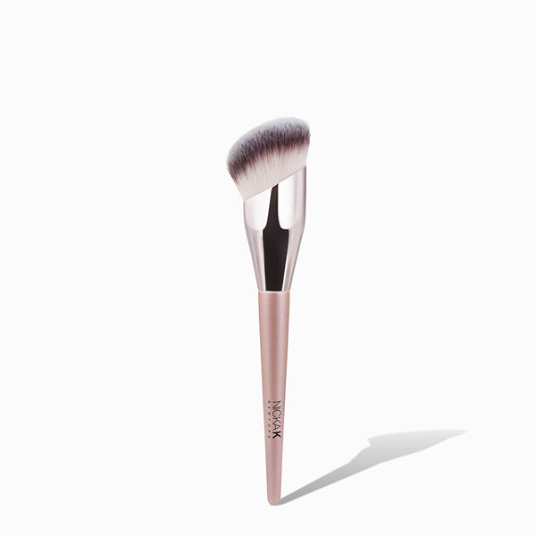 NICKA K angled foundation brush with dense synthetic bristles and rose gold handle