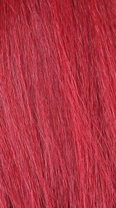 NUTIQUE Illuze Livia HD lace wig close up of vibrant red synthetic hair texture for bold fashion looks