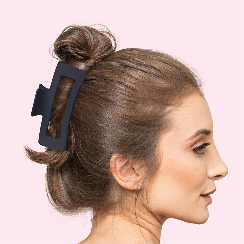 Woman with brown hair in a messy bun secured by a jumbo matte black claw clip for everyday styling