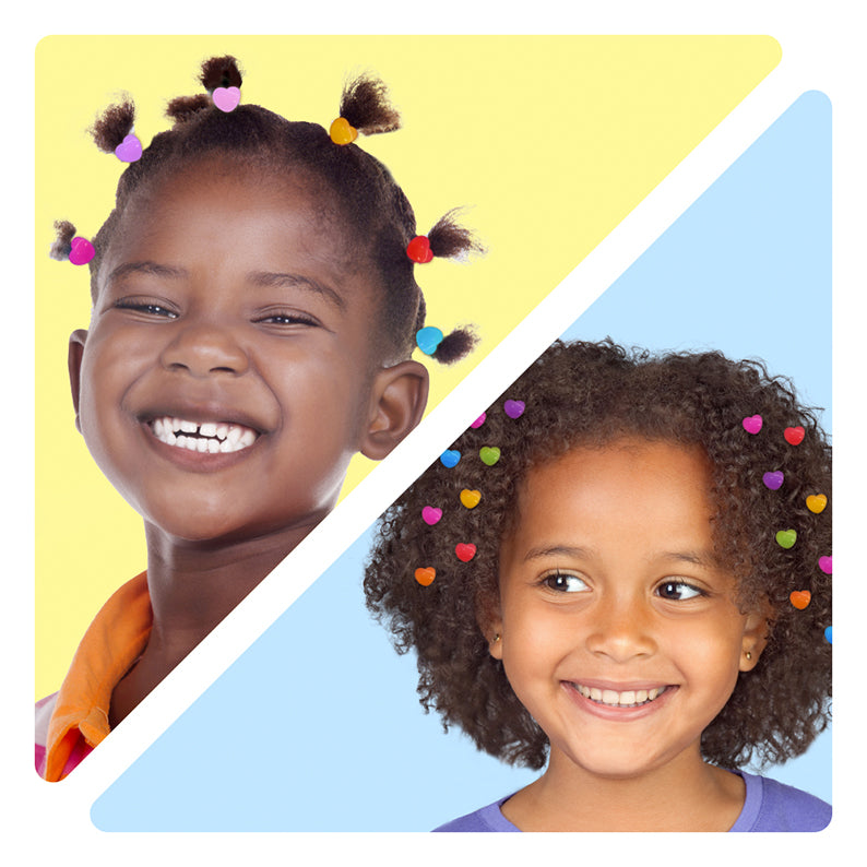 Two smiling girls wearing colorful kids heart hair clips in pigtails and scattered in curly hair