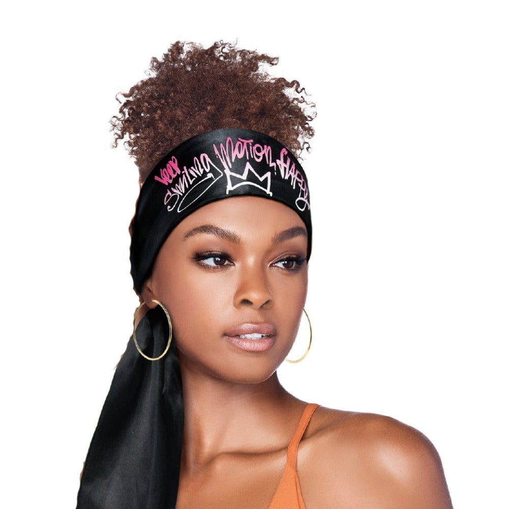 RED BEAUTY by KISS black satin edge scarf for hair with pink graffiti crown print tied on model with curly high puff