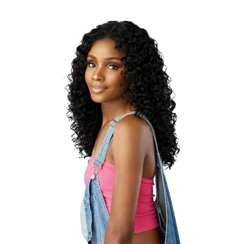 SENSATIONNEL lace front wig with 90s bangs in deep curly black on model wearing pink top and denim overalls