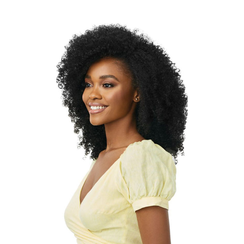 OUTRE synthetic curly half wig on smiling woman with voluminous natural black curls and yellow dress