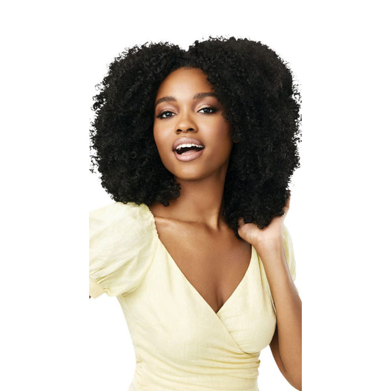 OUTRE synthetic curly half wig in natural black on smiling model with voluminous afro curls
