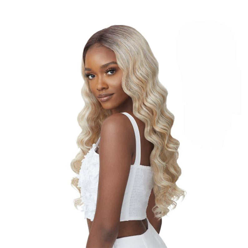 OUTRE long wavy blonde lace front synthetic wig with dark roots on model wearing white crop top