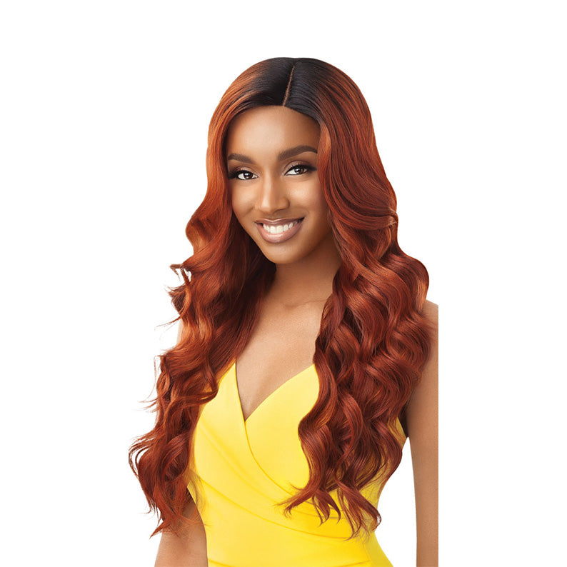 Kamala 26 inch synthetic lace wig by OUTRE auburn wavy long hair with deep side part on smiling model