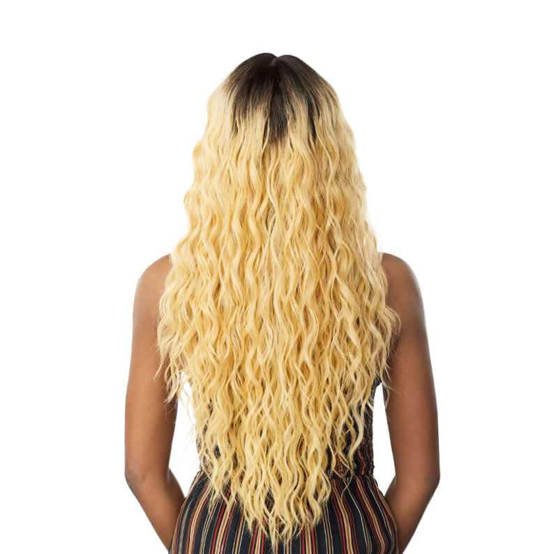 Back view of SENSATIONNEL Butta Lace Unit 11 wig long wavy blonde hair with dark roots on model